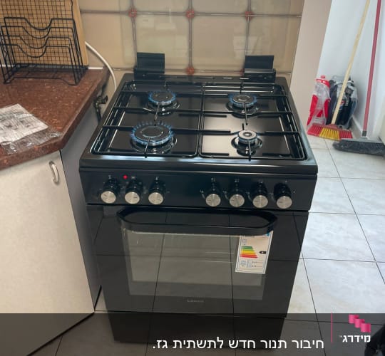 תנור גז שחור במטבח עם כיריים דולקות